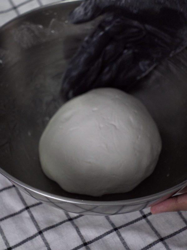 A smooth, firm ball of rice flour dough in a steel bowl