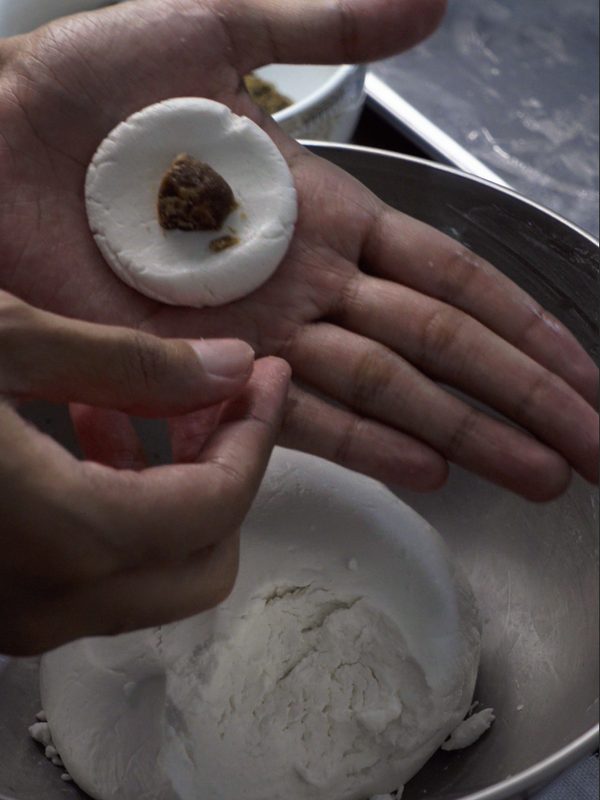 A flattened disc of dough with a piece of jaggery in the centre